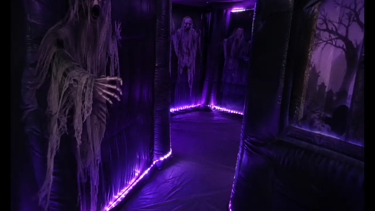 Interno di labirinto gonfiabile scuro a tema casa stregata con illuminazione LED viola